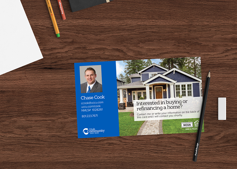 card on desk with mortgage loan officer and house